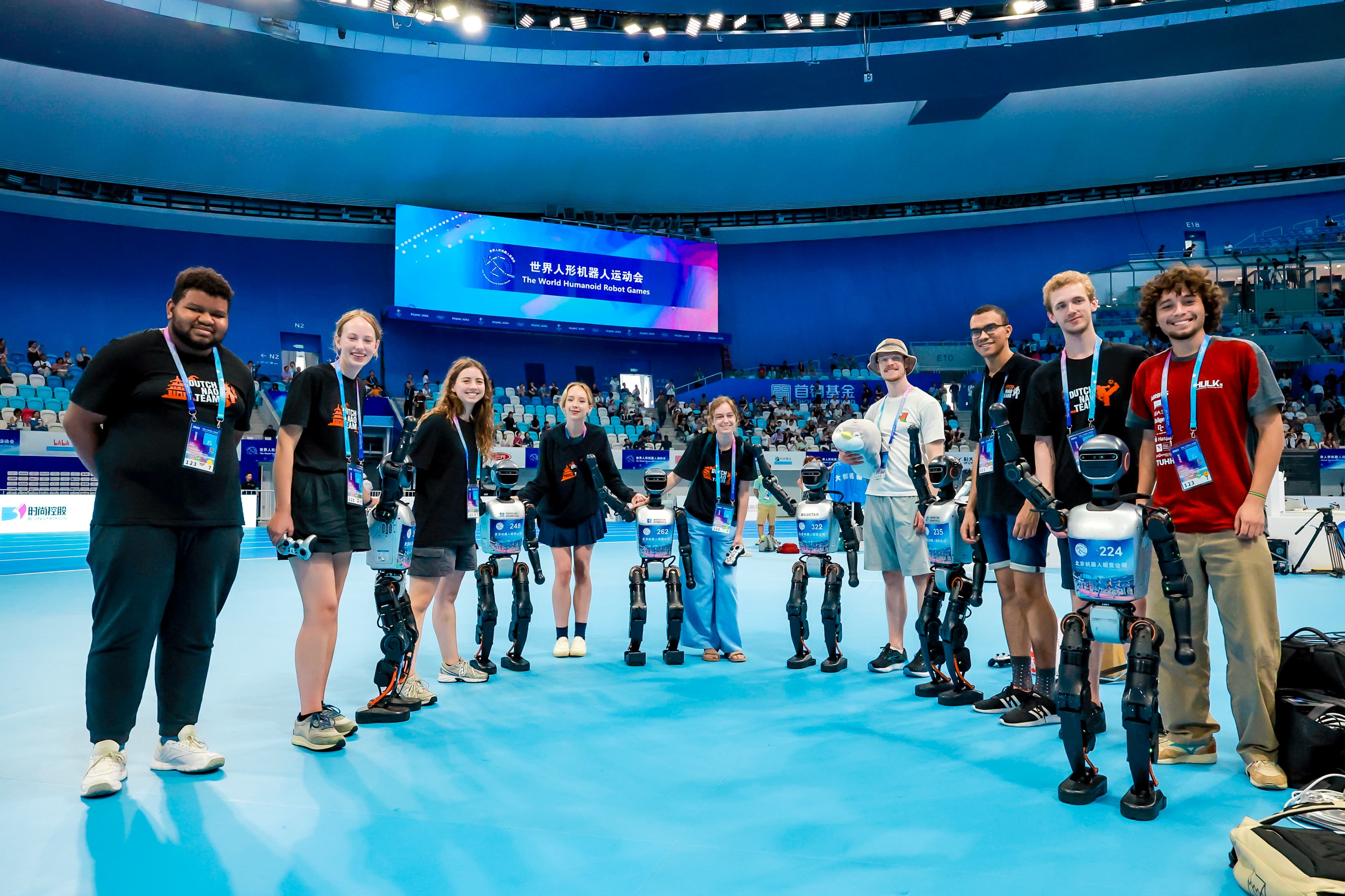 Team posing with the robot at the World Humanoid Robot Games showcase.